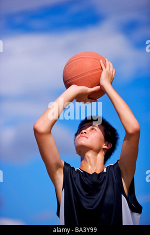 Teenage boy preparing to throw basketball Stock Photo