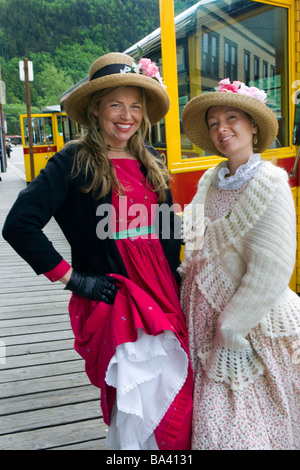 Skagway Streetcar Company tour guides dressed in period costume pose next to  streetcars in Skagway, Alaska Stock Photo