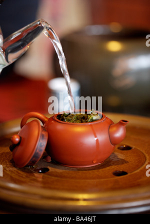 Water being poured into teapot on tray Stock Photo