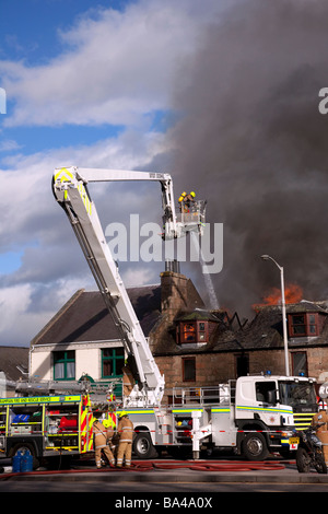 Firemen fighting Shop fire. Firefighter at scene at George Strachan’s of Aboyne, Aberdeenshire, Scotland Stock Photo