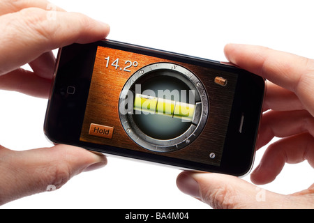 Male hands holding iPhone smartphone smart phone mobile phone using a spirit level application Stock Photo