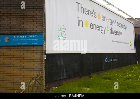 ClearChannel advertising billboard for BP on hoarding next to church in Newport South Wales UK Stock Photo