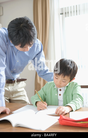 Japanese boy doing homework with his father Stock Photo