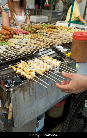 A close up of grilled bangkok meat balls & squid skewers on a Bangkok street grill Stock Photo