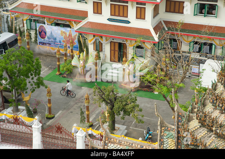 A thai cycles pasts two steam spitting dragon statues Wat Arun Bangkok Thailand Stock Photo