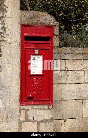 Close up of a red Post box set in the wall, Bibury, Gloucestershire, UK Stock Photo