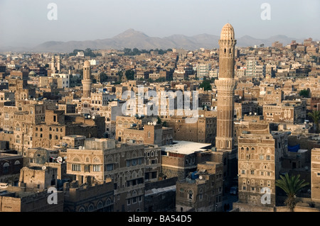 A minaret and traditional tower houses on the skyline of the old city of Sana'a, Yemen. Stock Photo