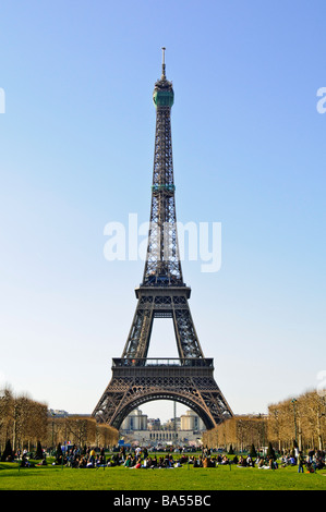 PARIS, France — The Eiffel Tower rises against a clear blue sky on a spring day in the French capital. The iconic wrought-iron lattice structure stands tall over the Champ de Mars, its distinctive silhouette a defining feature of the Parisian skyline. Stock Photo