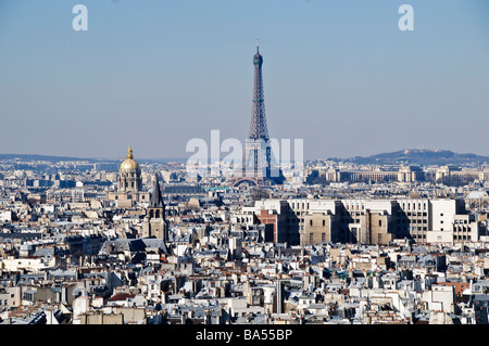 PARIS, France — The Eiffel Tower stands prominently against the Paris skyline on a clear, sunny morning. The iconic iron lattice structure rises above the city's rooftops, its silhouette unmistakable against the blue sky. Stock Photo