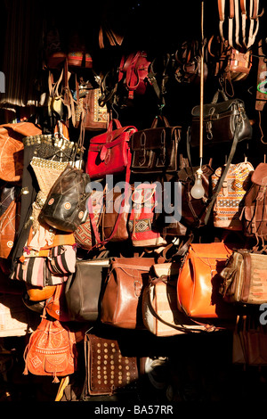 Selection of various designs of traditional hand made leather bags on display in the evening sunshine in the souks of Marrakech Stock Photo