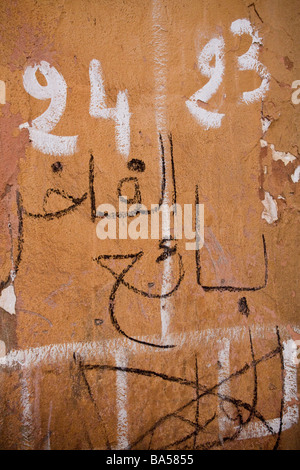 Hand drawn and painted graffiti in arabic and english on a coloured wall in the Medina, Marrakech Stock Photo