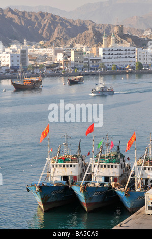 Waterfront and three fishing boats moored at Port Sultan Qaboos at Muttrah also spelt as Mutrah part of Muscat Oman Stock Photo