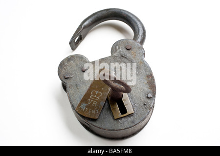 Old Victorian padlock and key, opened, with key in keyhole. Stock Photo