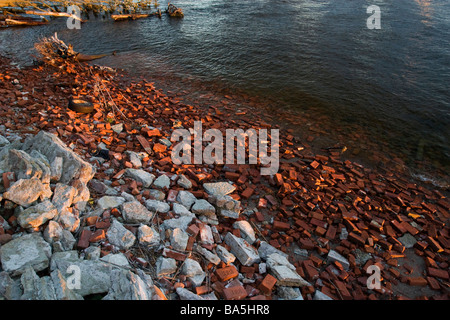 Beach covered with crashed bricks stones and over garbage. Stock Photo