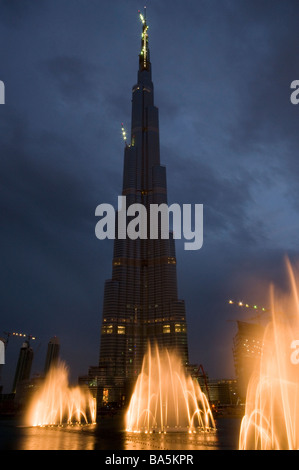 Dubai Fountains illuminated in the evening with the world's tallest skyscraper Burj Khalifa at Dubai Mall in UAE Stock Photo