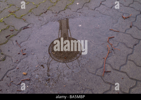 The Space Needle in Seattle is reflected in a pond of water on the ground Stock Photo