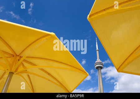Toronto CN tower between two yellow metal beach umbrellas at urban beach of HTO Park Stock Photo
