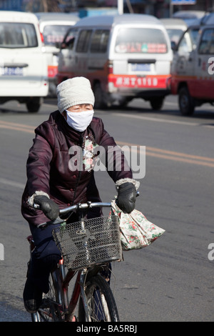 A cyclist wearing a smog mask against the awful air pollution in Shihua city in northern China Stock Photo