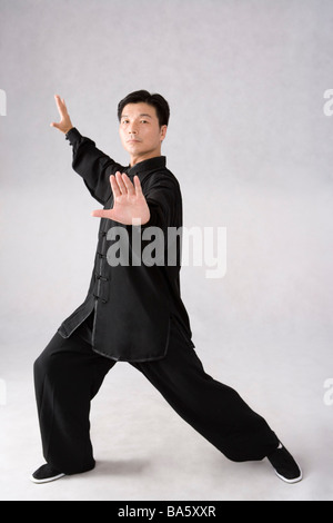 Man practicing Tai Chi against white background Stock Photo