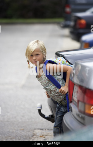 School-way girls carefully cars parks looks series people child schoolchild 7 years blond braids backpack school satchels Stock Photo