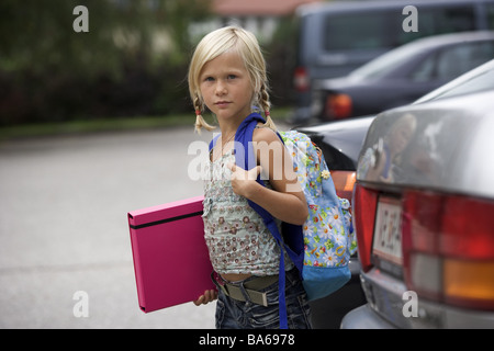 School-way girls carefully cars parks looks series people child schoolchild 7 years blond braids backpack school satchels Stock Photo