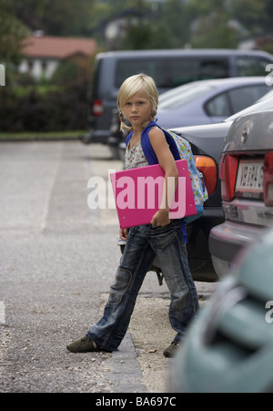 School-way girls carefully cars parks looks series people child schoolchild 7 years blond braids backpack school satchels Stock Photo