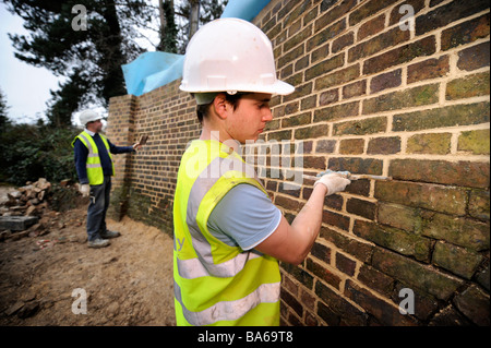 WORKERS REPAIRING HERITAGE BRICKWORK AT OIL MILLS BRIDGE NEAR STONEHOUSE AS PART OF THE RESTORATION WORKS ON THE STROUDWATER NAV Stock Photo