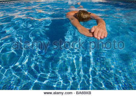 People swimming laps in a pool during a triathlon competition Stock
