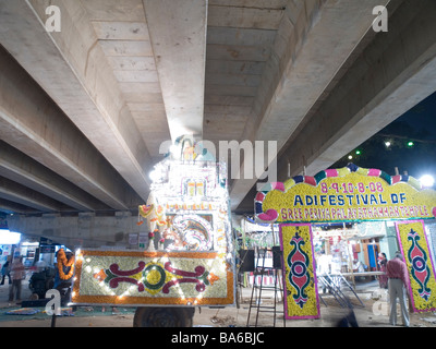 Workers build chariot for temple parade under highway Stock Photo