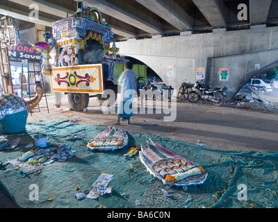 Workers build chariot for temple parade under highway Stock Photo