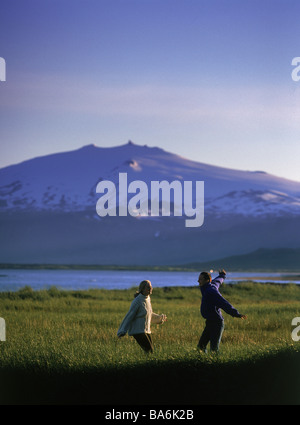 Couple having fun in the countryside with Snaefellsjokull glacier in background, Iceland Stock Photo