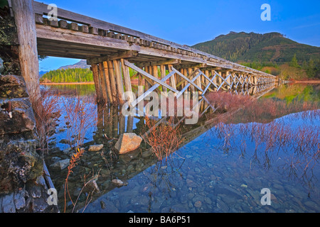 Old wooden bridge spanning the entrance to Clayoquot Arm of Kennedy Lake, a transition area of the Clayoquot Sound UNESCO. Stock Photo