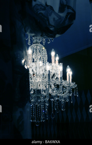 elegant glass chandelier light fitting in dark room Stock Photo