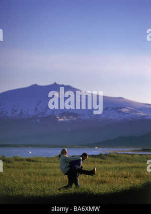 Couple having fun in the countryside with Snaefellsjokull glacier in background, Iceland Stock Photo