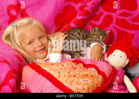 Girls smiles kittens doll cuddle lies portrait series people 5 years child-portrait child toddler blond gaze camera childhood