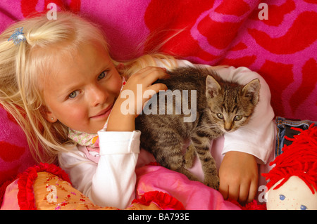 Girls smiles kittens doll cuddle lies portrait series people 5 years child-portrait child toddler blond gaze camera childhood