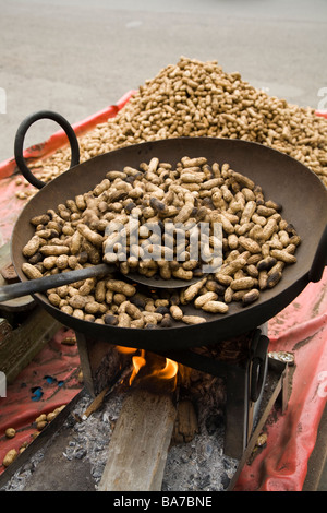 Street vendor's roasting peanuts over an open burner and selling them in Surat. Gujarat. India. Stock Photo