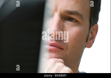 man looking at computer monitor Stock Photo