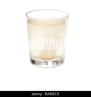 Effervescent vitamin C tablet dissolving in a glass of water. Isolated on a white studio background. Stock Photo