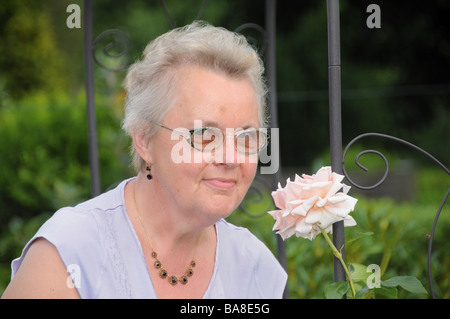 Europe, Germany, hamburg, grandmother with a pink rose in her garden Stock Photo