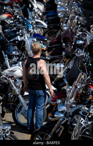 Man surveys parked motorcycles lining street annual Sturgis Rally South Dakota USA Stock Photo