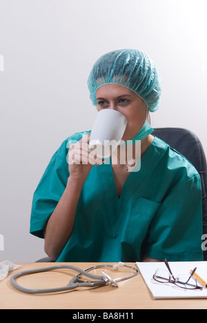 Doctor sat in office drinking coffee Stock Photo