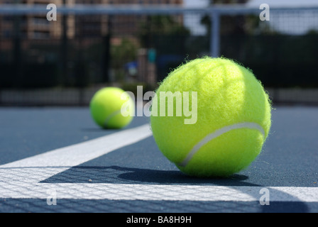 Two tennis balls with net in background Stock Photo