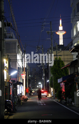 Back street alley in Kyoto at night with the Kyoto Tower raising above Japan Stock Photo