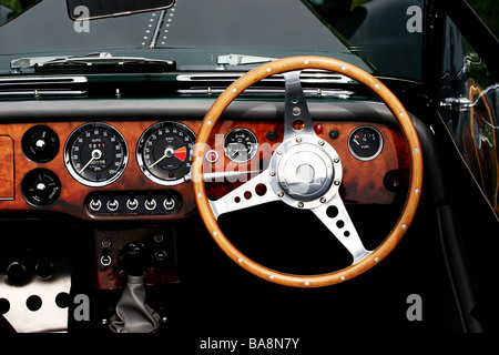 Drivers-eye view of the wooden steering wheel, dashboard and instrument panel of a classic, vintage car Stock Photo