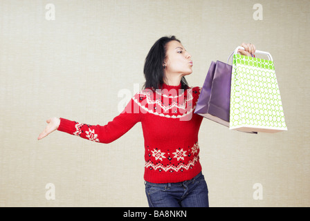 Playful lady with gift bags in the red sweater Stock Photo