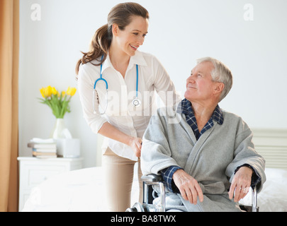 Nurse helping senior man in wheelchair Stock Photo