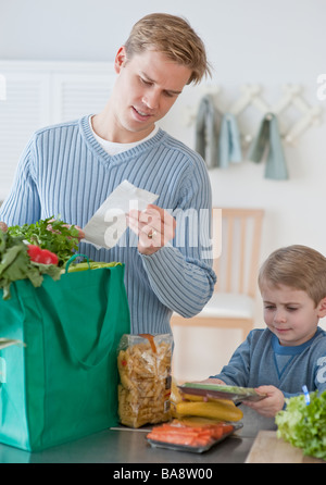 Father and son unpacking groceries Stock Photo