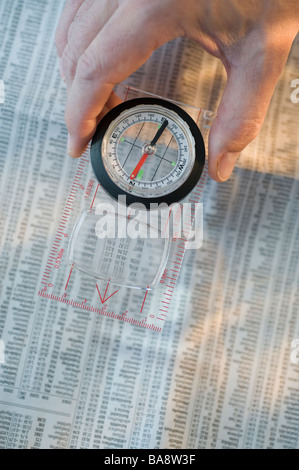 Man holding compass over stock pages Stock Photo