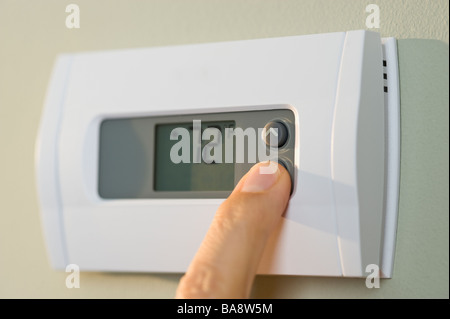 Man adjusting thermostat Stock Photo